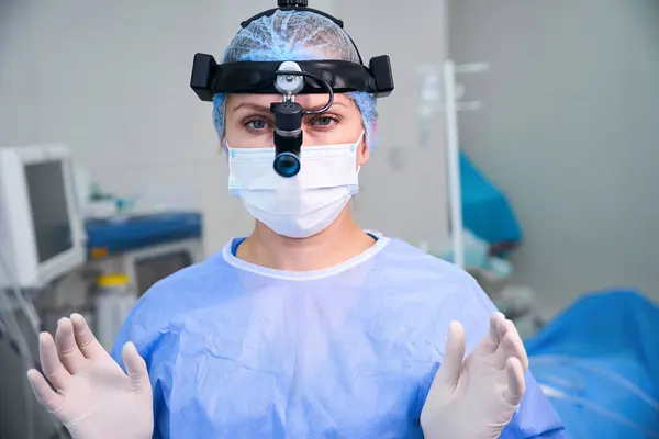 stock image Female otolaryngologist surgeon is ready to perform surgery, she is in full surgical gear