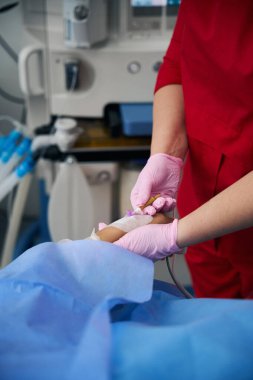 Surgical nurse prepares a patient for surgery, she injects a drug into a vein clipart