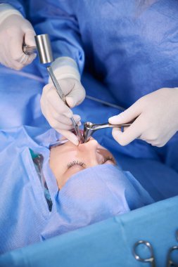 Cerrahi hemşire ameliyatta cerraha yardım eder, hasta adenotomi olur.