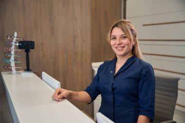 Resepsiyondaki bayan resepsiyonist müşterilere hoş geldin jesti için yardım etmeye hazır.