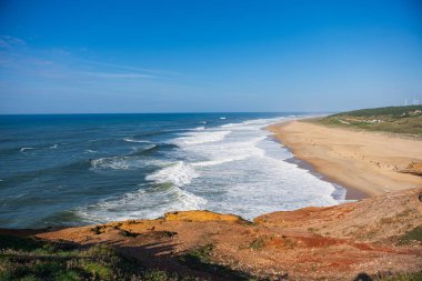 Ocean view of Plaia du Norte in Nazare, Portugal. Mavi okyanus gelgiti ve altın kum. Sörf, seyahat, manzara konsepti