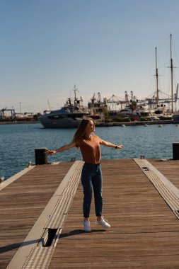 Valencia, İspanya 'da lüks yatların yanında yürüyen güneş gözlüklü mutlu bir bayan. Seyahat, turizm, tatil, tatil kavramı