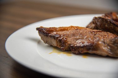 Beyaz arka planda sığır eti kesimi. Lifli diyet. Barbekü. Kızarmış ve az pişmiş et. Sığır etli yemek. İhracat için özel et parçaları.