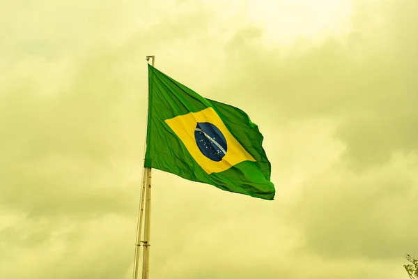 Brazilian flag flying on an iron bar. National symbol. Pavilion. Symbol of the Federative Republic of Brazil. coat of arms. National identity. Green and yellow flag.