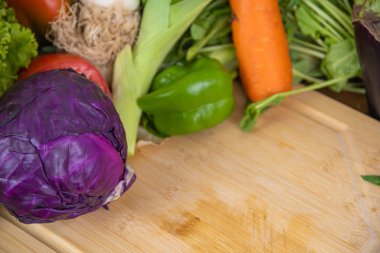 Tahtanın üstünde kırmızı lahana sebzesi. Salatalar için malzemeler. Doğal yiyecekler. İnsan kullanımı ve tüketimi için sebzeler. Sağlıklı beslenme. Sebze ve salata..