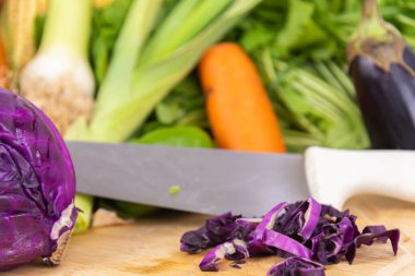 Tahtanın üstünde kırmızı lahana sebzesi. Salatalar için malzemeler. Doğal yiyecekler. İnsan kullanımı ve tüketimi için sebzeler. Sağlıklı beslenme. Sebze ve salata..