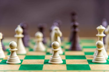 Yeşil tahtada satranç taşları. Mantık ve strateji oyunu. Kralların oyunu. Eğlence ve rekabet.