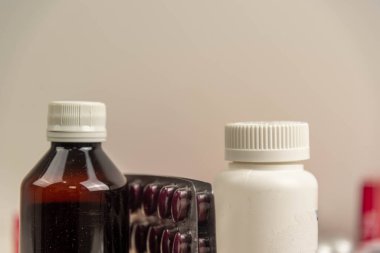 Tarafsız bir zeminde ilaç ve ilaç şişeleri. Oral kullanım için ilaçlar. İlaç şişeleri ve hap paketleri. İnsan sağlığı için kullanılan eşyalar. Hastane malzemeleri..