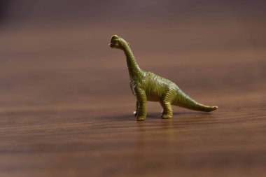Tahta yüzeyde oyuncak dinozorlar. Oyuncaklar. Dinozorlar Parkı. Minyatürler ve koleksiyonlar. Çocuklar için hediyeler. Macera ve eğlence.