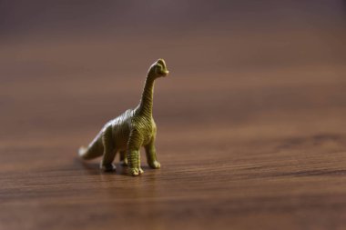 Tahta yüzeyde oyuncak dinozorlar. Oyuncaklar. Dinozorlar Parkı. Minyatürler ve koleksiyonlar. Çocuklar için hediyeler. Macera ve eğlence.