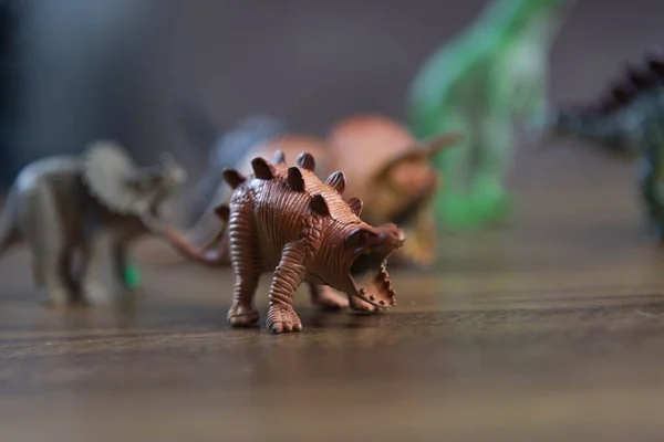 Toy dinosaurs on wooden surface. Toys. Dinosaurs Park. Miniatures and collections. Gifts for children. Adventure and fun.