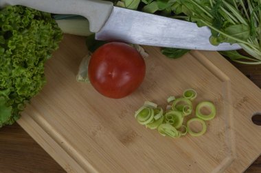 Tahtada kesilmiş sebzeler. Yenilebilir yiyecekler. Salatalar için malzemeler. Vejetaryen mutfağı. Sağlıklı beslenme.