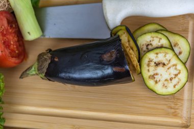 Tahtada kesilmiş sebzeler. Yenilebilir yiyecekler. Salatalar için malzemeler. Vejetaryen mutfağı. Sağlıklı beslenme.