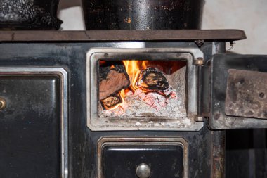 Odun sobası çalışıyor. Mutfak aletleri. Ateşli odun sobası. El yapımı soba..