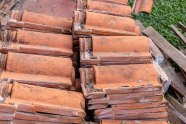 Duvarda eski kil kiremitler yığılıyor..