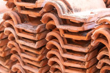 Duvarda eski kil kiremitler yığılıyor..