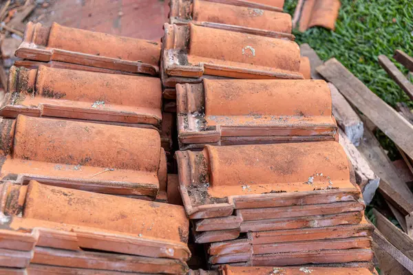 Duvarda eski kil kiremitler yığılıyor..