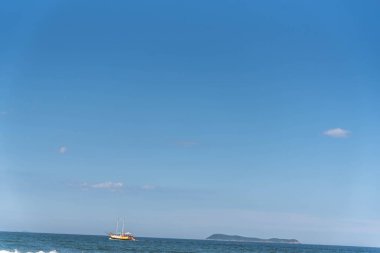 Tourist boat on the coast of Gamboa beach, Santa Catarina, Brazil.NEF. clipart