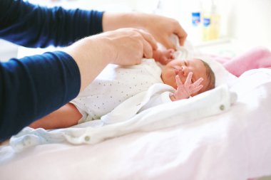 Father preparing newborn baby for the first bath 