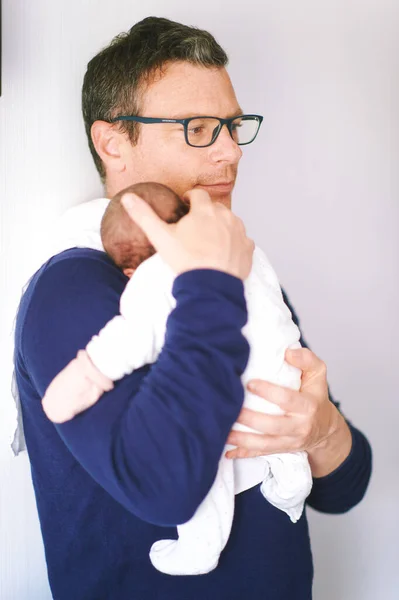 Middle age father holding  newborn baby