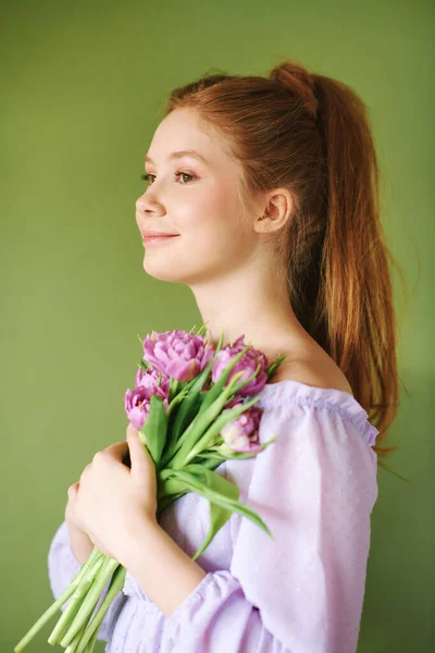 Yeşil Arka Planda Mor Bir Elbise Giymiş Elinde Lale Çiçekleri — Stok fotoğraf
