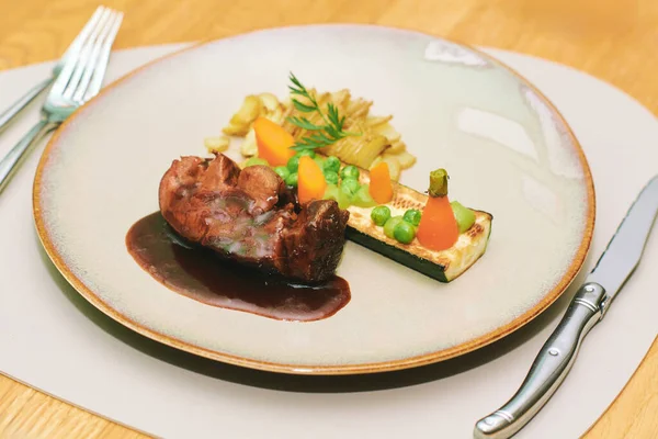 Sauteed beef tenderloin with red wine sauce served with seasonal vegetables