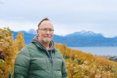 Outdoor portrait of middle age 55 - 60 year old man enjoing nice autumn day in vineyards, healthy and active lifestyle clipart