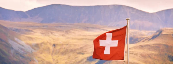 Swiss flag against swiss alpine mountain, fall season