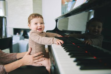 Piyanoyla oynayan sevimli bebek, küçük çocuklar için erken gelişim ve eğitim