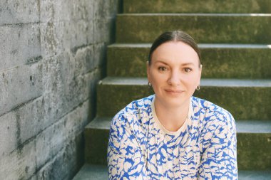 Dışarıda poz veren 40-45 yaşlarında güzel bir kadının moda portresi.