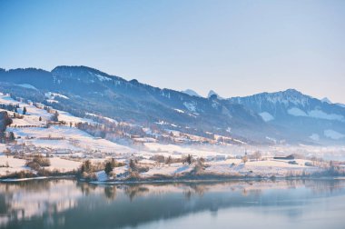 Winter landscape of Lake Gruyere covered with snow clipart