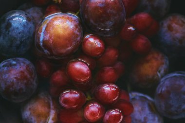 Mor erikli arka plan ve suda kırmızı üzümler