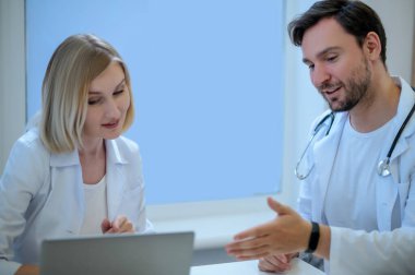 Hastanede çalışma günü. İki doktor yan yana oturup bir şeyi tartışıyor.