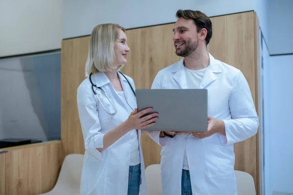 Beyaz Laboratuvar Önlüklü Sağlık Görevlileri Laptopu Bir Arada Tutuyorlar Konuşma — Stok fotoğraf