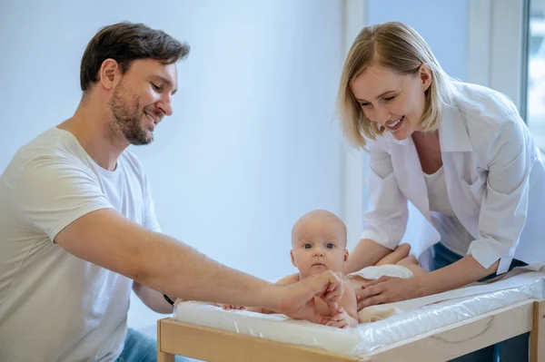 Fröhlicher Kinderarzt Überprüft Die Reflexe Eines Neugeborenen Unterstützt Von Einem — Stockfoto