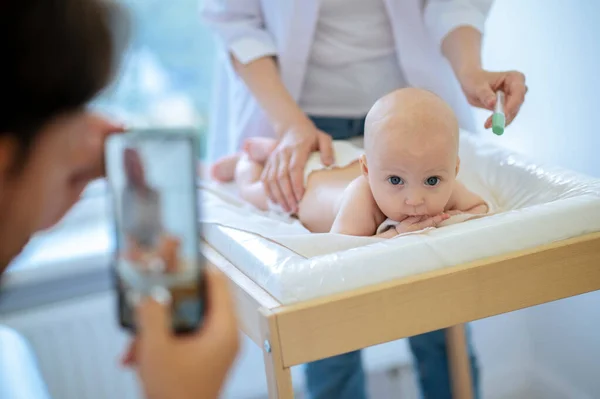 在儿科医生进行体格检查时 家长给新生儿拍照 让新生儿冷静下来 — 图库照片