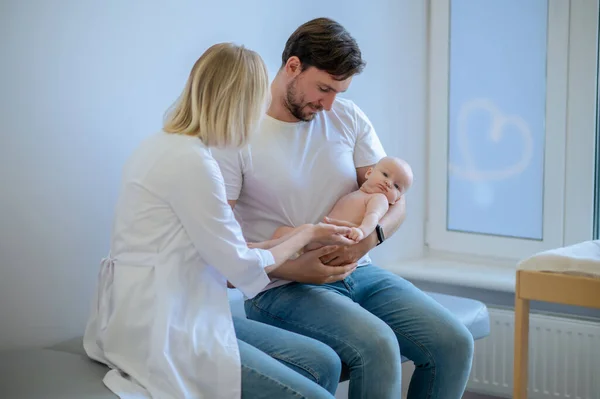 Mann Hält Das Neugeborene Während Der Ärztlichen Untersuchung Durch Einen — Stockfoto