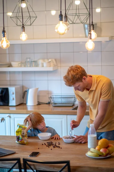 家で朝だ 幼い息子のために朝食を作る若い父親 — ストック写真