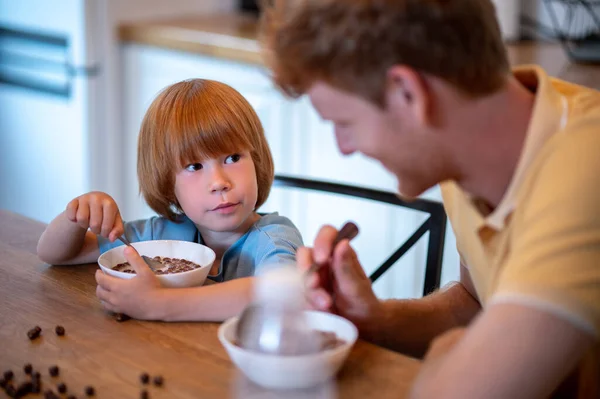 朝食を一緒に 父と息子はテーブルに座って朝食を食べる — ストック写真