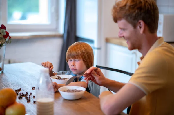 朝食を一緒に 父と息子はテーブルに座って朝食を食べる — ストック写真