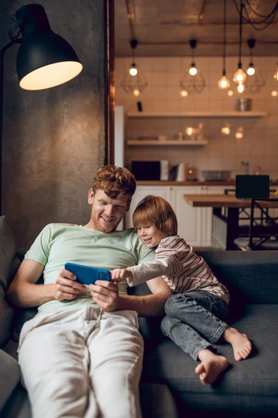 온라인으로 귀여운 아버지는 앉아서 태블릿에서 온라인 게임을 — 스톡 사진