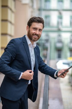 Başarılı bir iş adamı. Başarılı bir işadamı tabletle halinden memnun görünüyor.