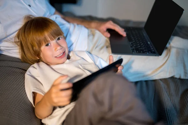 Cyfrowy Świat Ojciec Syn Leżący Łóżku Spędzający Czas Internecie — Zdjęcie stockowe