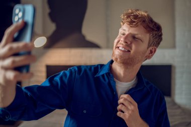 Kendine güven. Gülümseyen kızıl adam özçekim yapıyor ve kendinden emin görünüyor.