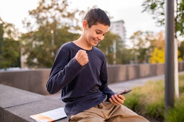 Χαμογελώντας Χαρούμενος Έφηβος Κάθεται Στο Τσιμεντένιο Χειρολισθήρα Έξω Και Κοιτάζοντας — Φωτογραφία Αρχείου