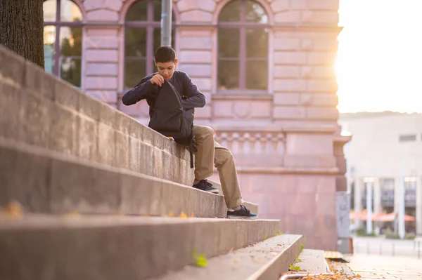Ciddi Odaklı Genç Çocuk Beton Merdivenlerde Oturuyor Sırt Çantasını Karıştırıyor — Stok fotoğraf