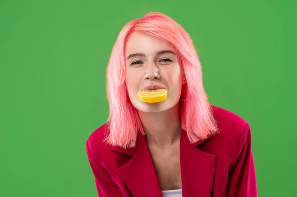 Portret Młodej Kobiety Plasterkiem Cytryny Ustach Zielonym Tle — Zdjęcie stockowe