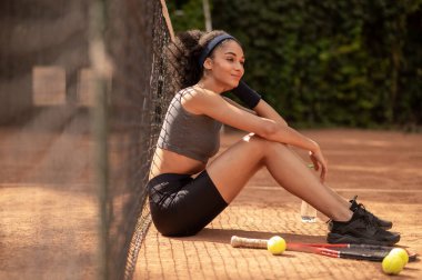 Tenis oyuncusu. Güzel siyah saçlı kız oyundan sonra dinleniyor.