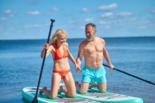 Kayaking. Mature sporty couple in the sea kayaking