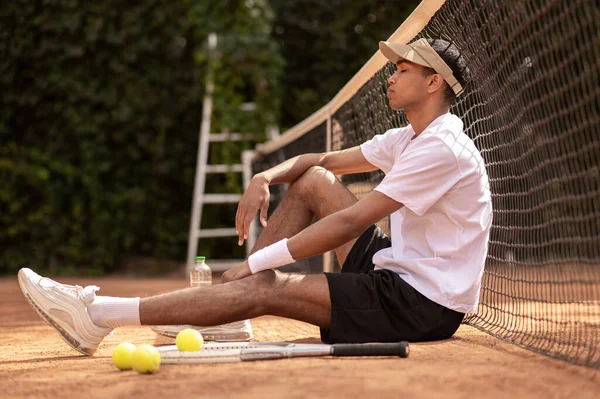 年轻人坐在网球场休息 — 图库照片